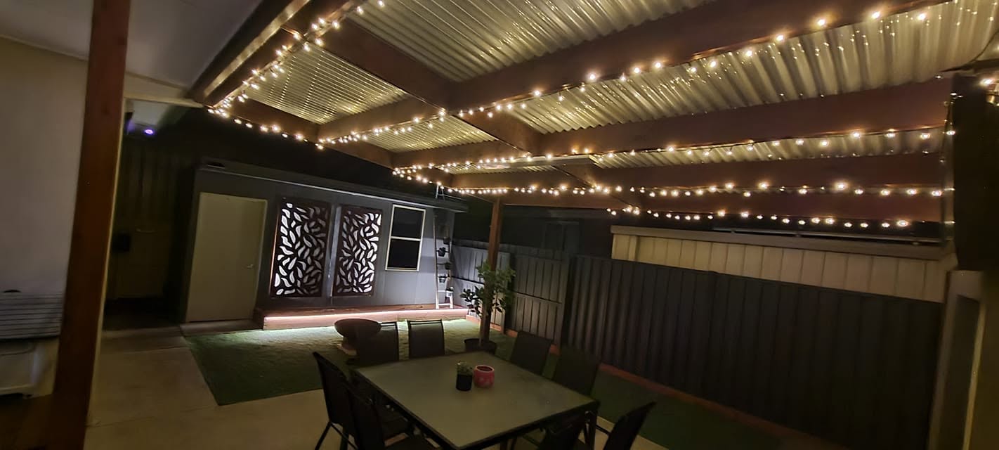 Outdoor patio and pergola area illuminated with decorative festoon string lights, showcasing expert Lighting & Powerpoint Installation in Geelong.